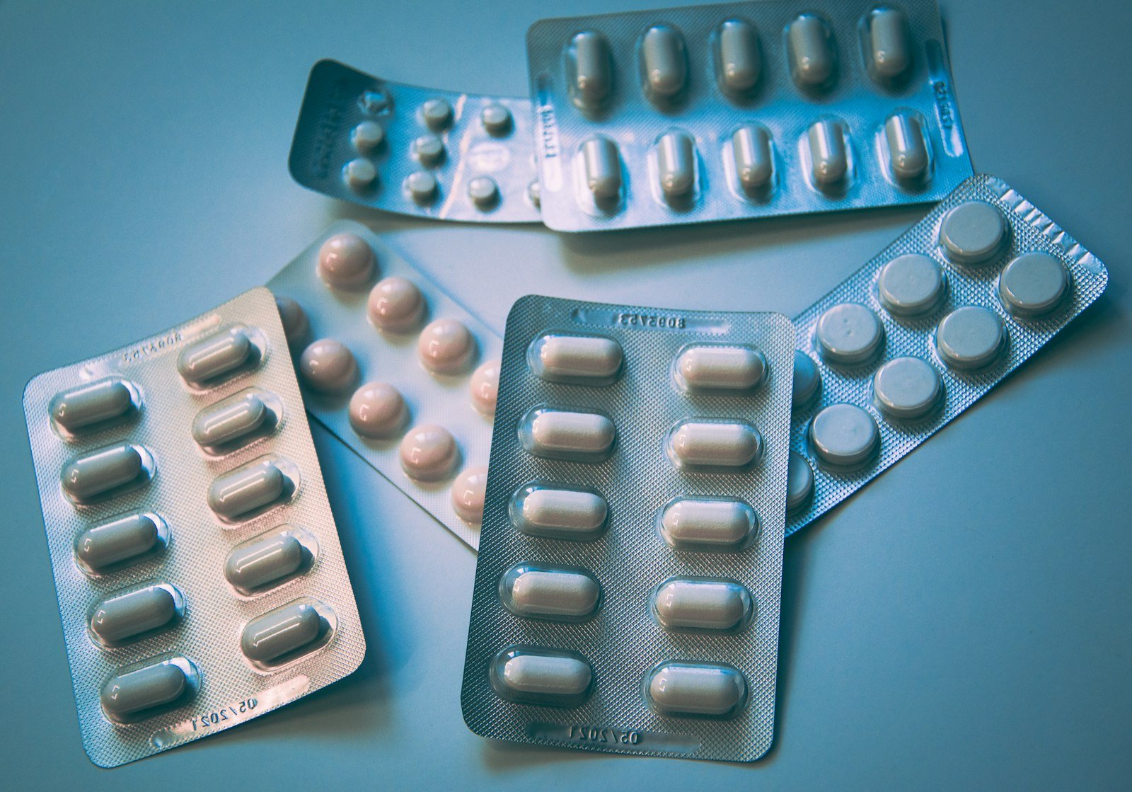 Blister packs of tablets under cool blue lighting